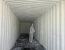 Worker applying a coating inside a corrugated metal container